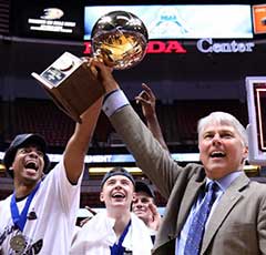 Photo: Coach Jim Les hoists Big West tournament trophy, surrounded by his team