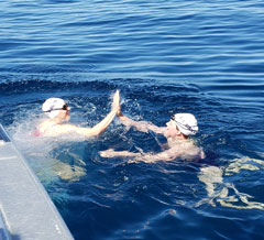 Photo: Heather Bischel and Ann Willis touch hands while swimming, as they trade places in the Trans Tahoe Relay swim
