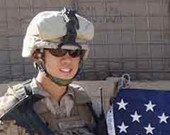 Alan Sung, 2006 graduate, in Marine uniform, next to American flag
