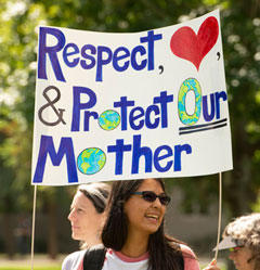 Photo: Woman holds sign, 'Respect, Love & protect Our Mother (Earth)'