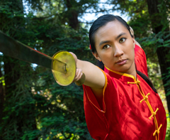 Photo: 2018 University Medalist Emily Eijansantos, in Chinese gown, thrusts sword in demonstration of wushu martial arts