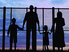 Photo: A family stands at a fence
