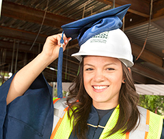 Photo: UC Davis senior Maria Munoz adjusts grad cap atop her Devcon Construction hard hat.