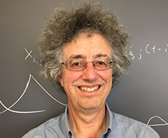 Photo: Professor Alan Hastings in front of diagram on chalkboard
