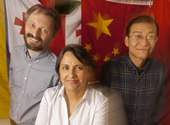 Photo: 2015-16 Humphrey Fellows, from left, Kakhaber Bakhtadze, Tania Guzmán and Zhao Zhong, standing in front of flags
